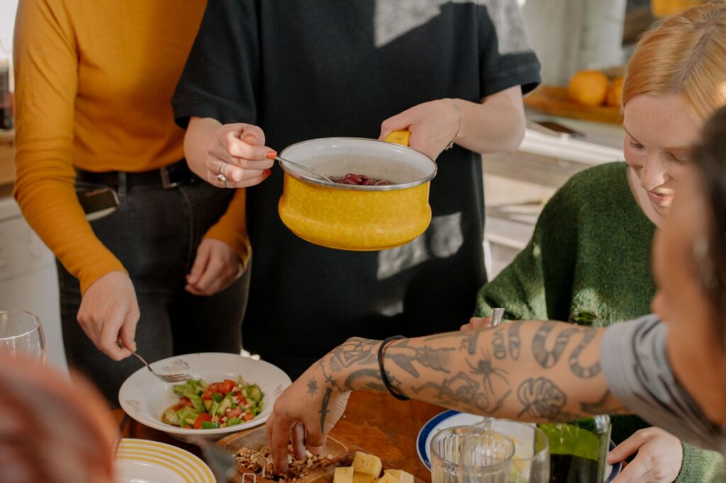 A group of friends enjoying a veggie meal together in a bright kitchen setting