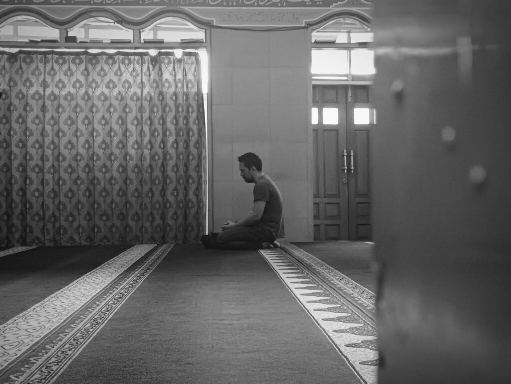 A man in prayer, seeking divine guidance and peace during times of conflict in relationships