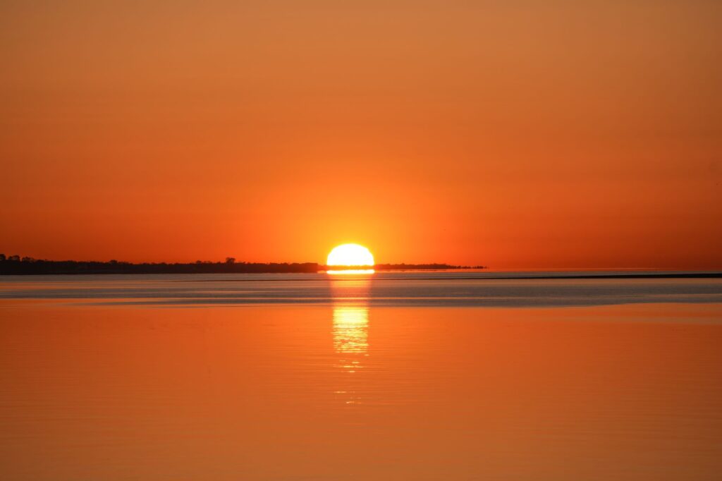 A serene sunset over calm water reflects the peace that comes from trusting God in life's uncertainties