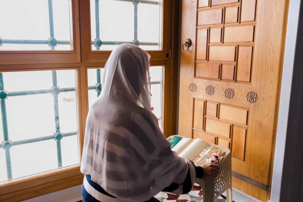 A woman in prayer at a window embodies the power of seeking God's presence during difficult times