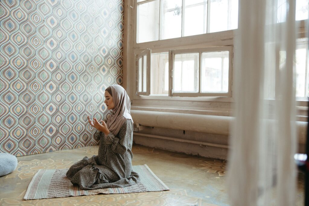 A woman in quiet prayer by a window, illustrating the importance of seeking God's guidance