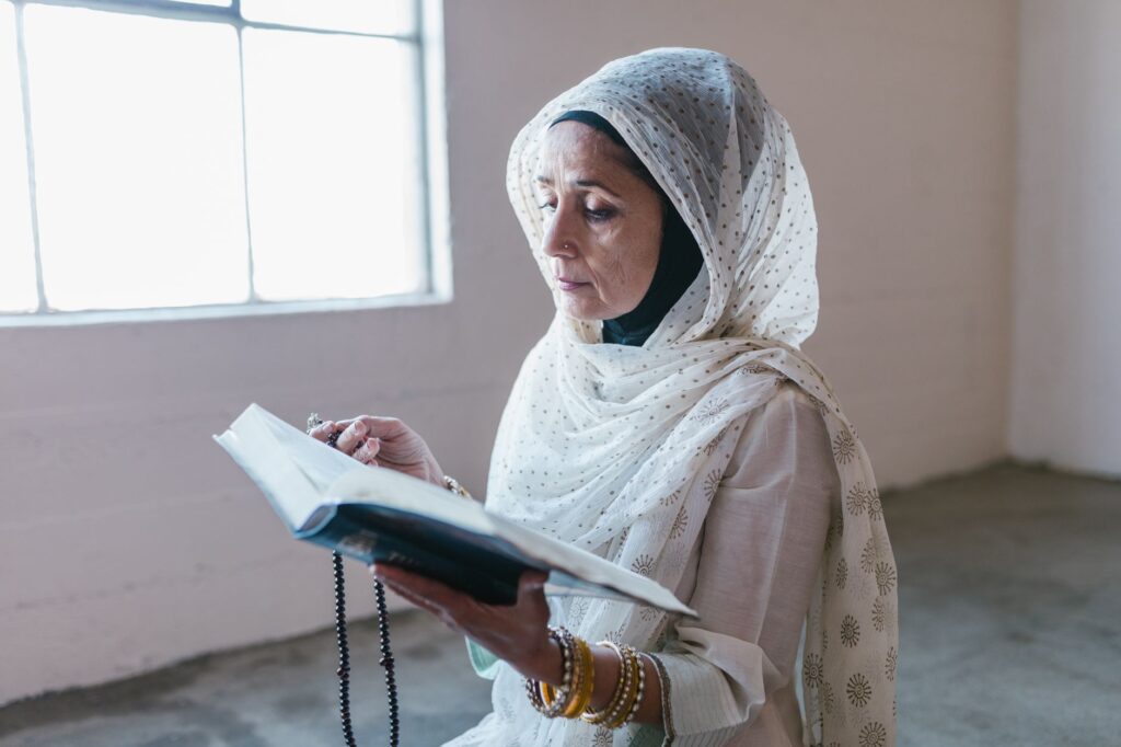 A woman praying by a window, illustrating the power of prayer in overcoming doubt